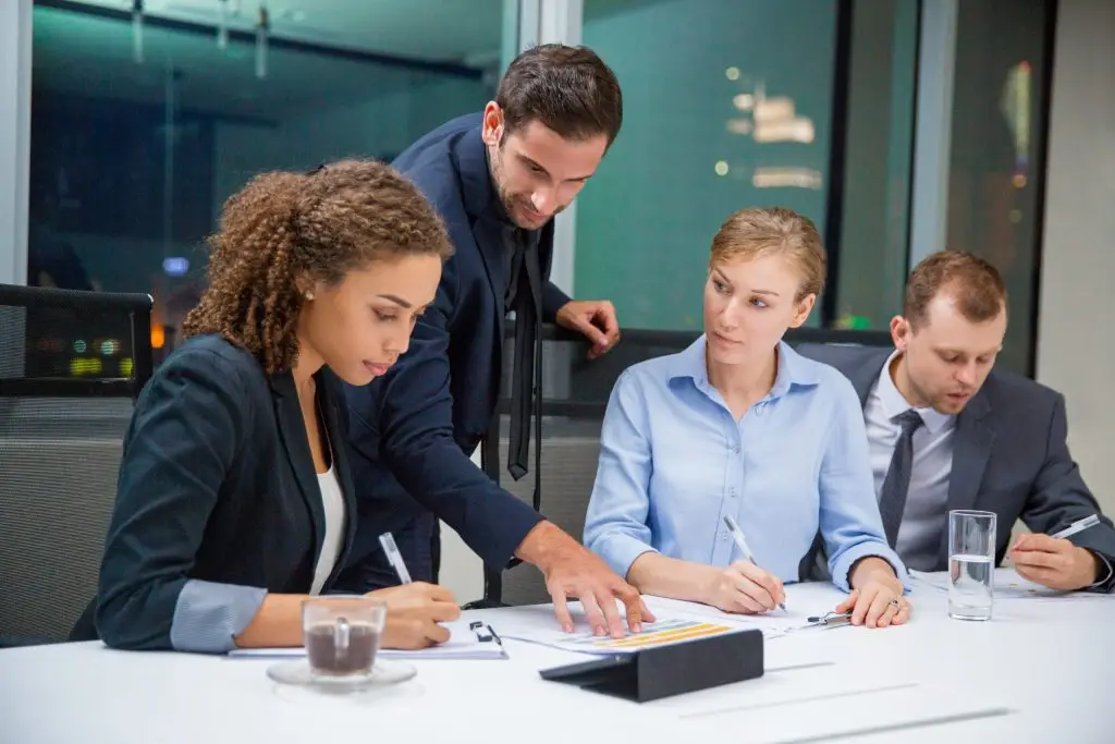 Business professional reviewing a document with two partners